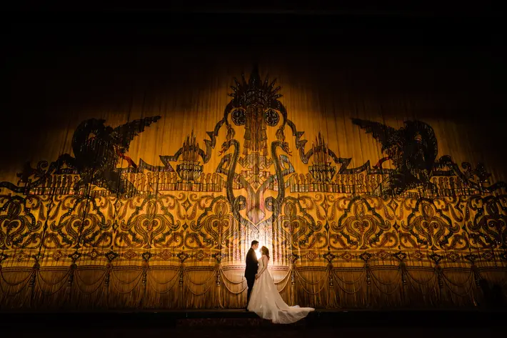 couple-in-spotlight-against-theater-curtain-vinson-images