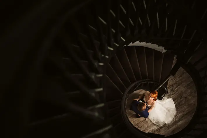 bride-looks-up-from-spiral-staircase-landing-lima-conlon-photography