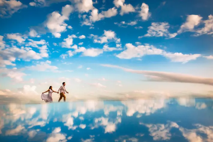 Bride and groom walking on the clouds with reflection - photo by area da fotographia - Braziel