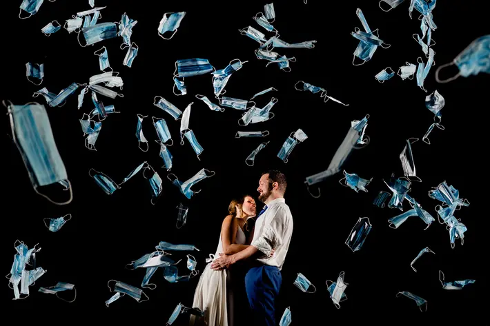 Photo of bride and groom showered by Covid masks - photo by Vinson Images