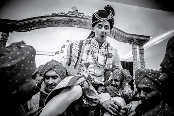 groom-makes-funny-face-as-he-is-carried-aloft-apresh-chavda-photography