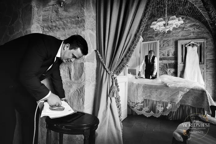 Grooms ironing suits during getting ready, by Edoardo Agresti