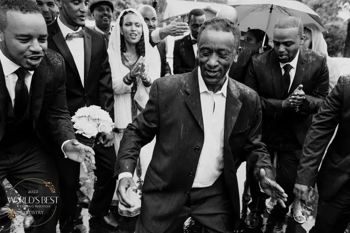 award-winning-black-and-white-photo-3-groom-and-party-walking-in-rain-photo-by-j-olson-weddings