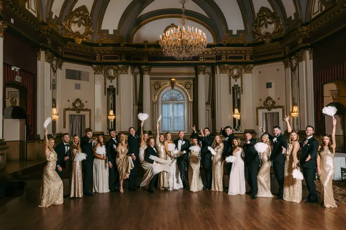 group-shot-in-black-white-and-gold-with-feathered-fans-in-classical-interior-nat-wongsaroj-photography