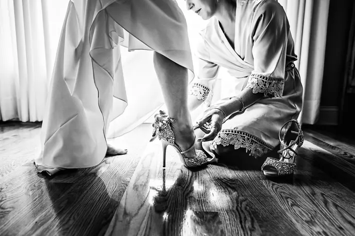 bride-getting-help-getting-her-heels-on-photo-by-michelle-arlotta-photography