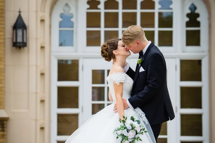 formal-profile-couple-kiss-with-bride-on-her-toes-tiffany-hofeldt-photography