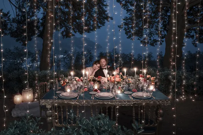 couple-at-outdoor-reception-table-in-evening-candlelight-with-string-lights-photo-by-joanne-dunn-photographers