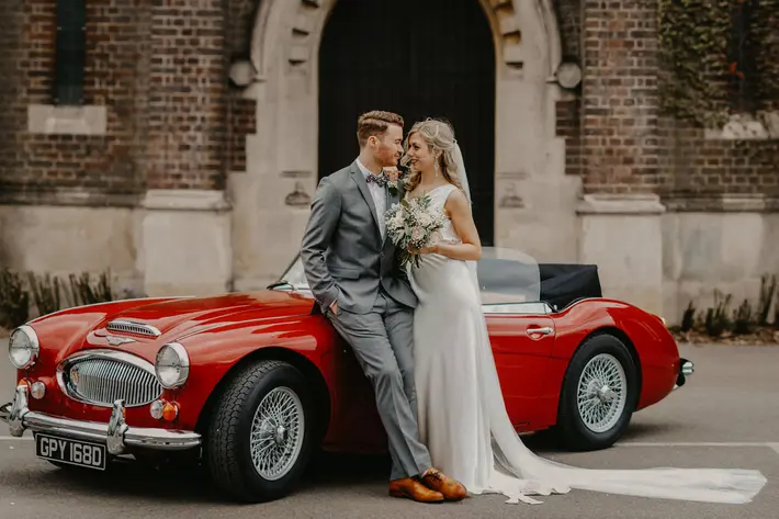 Couple portrait in front of red MGB sports car - photo by Miki Studios - London