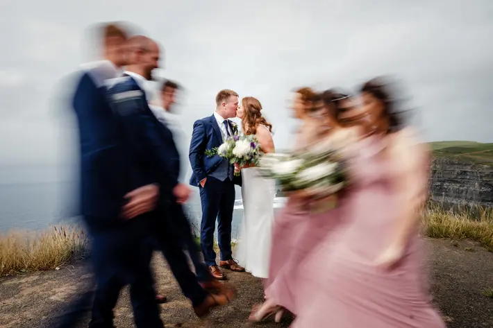 bridal-party-in-motion-as-couple-kiss-photo-by-ronan-palliser-photography
