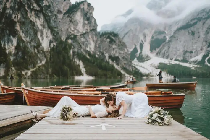 Brides kssing by Italian lake, photo by Stefano Cassaro