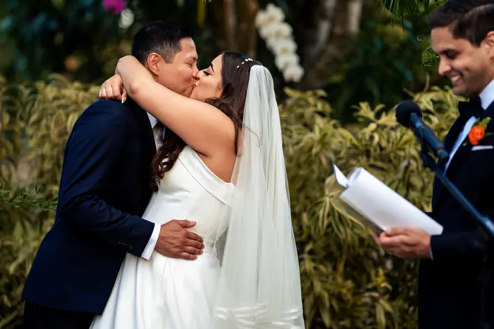 Ceremony kiss during wedding at Sunset Groves, Miami, photographed by Michael Freas Photography