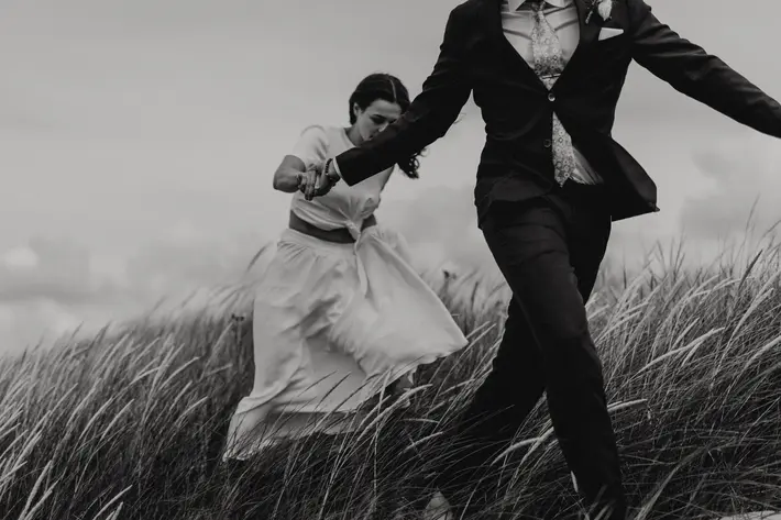 Couple walking in tall grass photo by Fotograf Lillian Nordbo