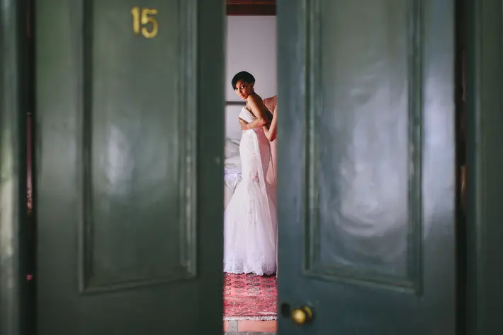 Bride getting ready seen through open interior doors Ruan Redelinghuys Photography