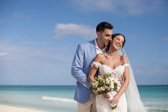 Bride with white wedding bouquet, beach portrait by M.E. Photo & Films, Cancun, Mexico wedding photographers,