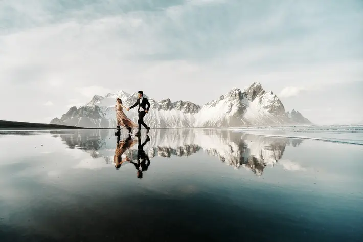 Engagement couple hand in hand snowy Iceland mountains M & J Studios