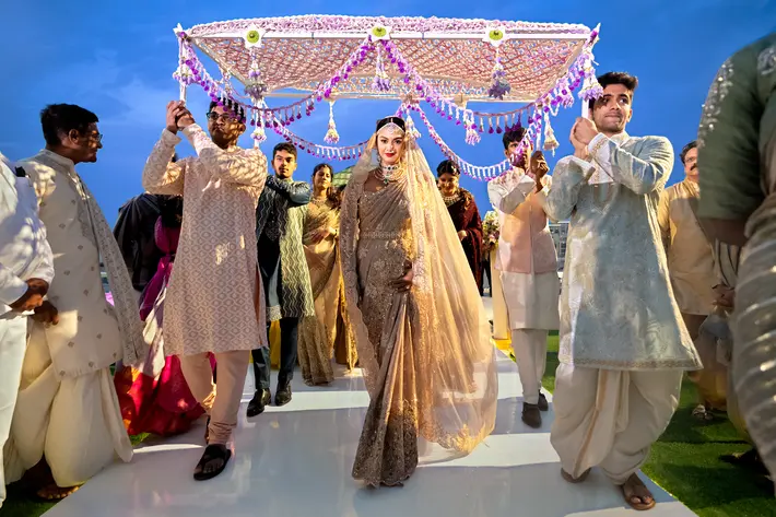 Indian wedding bride walking under canopy Two Mann Studios