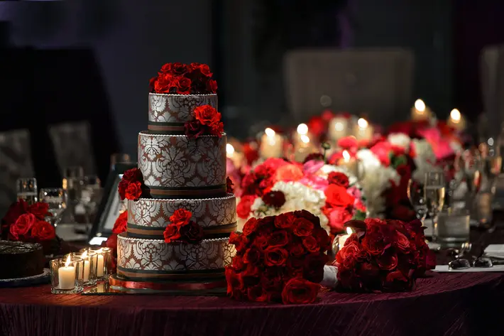 wedding cake decorated with red roses David and Sherry Photography