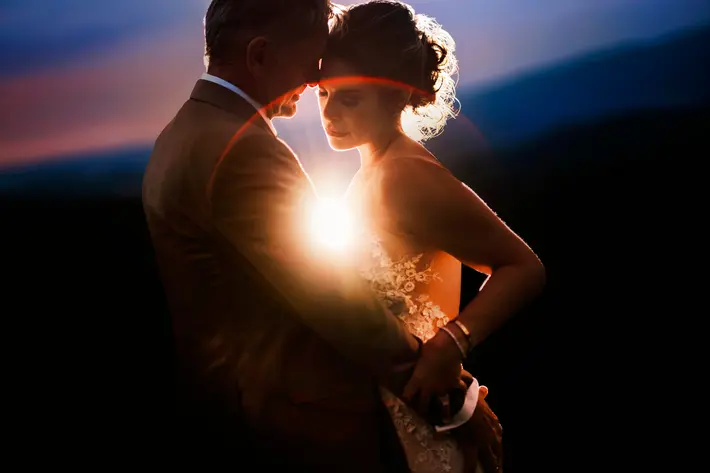 Couple in golden halo with lens flare, Chrisman Studios, destination wedding photographers